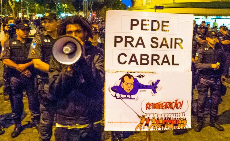“please, Cabral, leave us” the baiano on a protest befor his arrest. Cabral is shown in a helicopter, as his private helicopter was shot 2008 from a favela and this was the starting point for forming the UPP “please, Cabral, leave us” the baiano on a protest befor his arrest. Cabral is shown in a helicopter, as his private helicopter was shot 2008 from a favela and this was the starting point for forming the UPP